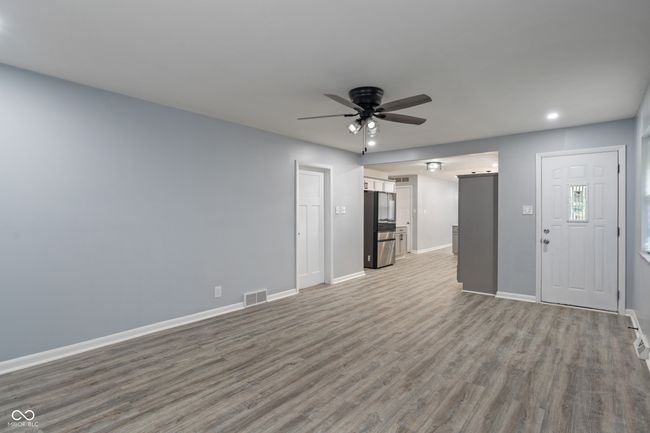 unfurnished living room with ceiling fan, wood finished floors, baseboards, and recessed lighting | Image 16