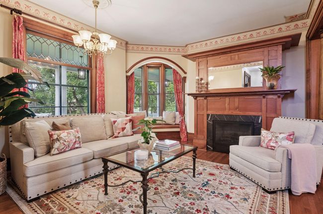 Living room with gas fireplace, window seat overlooks sloping front yard | Image 7