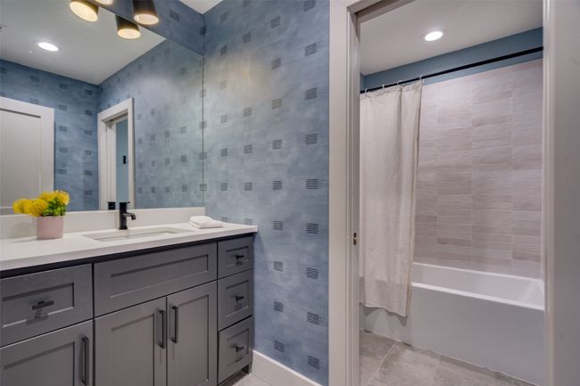 Bathroom featuring wallpapered walls, vanity, and shower / bath combo | Image 16