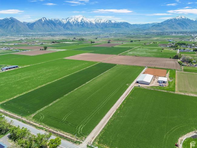 Aerial view of sparsely populated area featuring a mountainous background and abundant farmland | Image 7