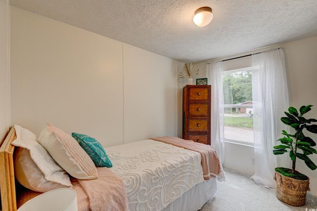 Bedroom with a textured ceiling and light carpet | Image 21