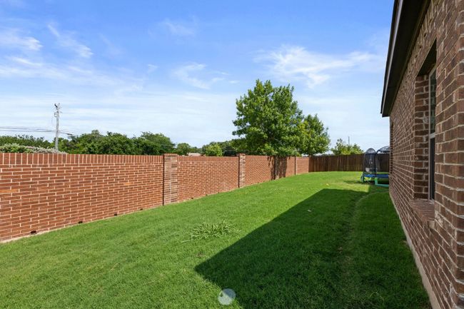 Fenced backyard with a trampoline | Image 25