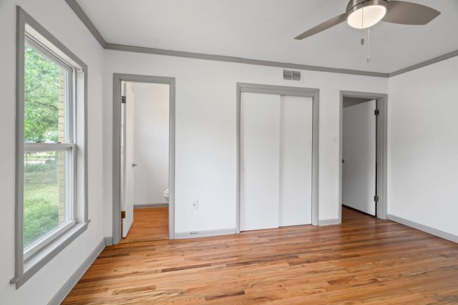 Unfurnished bedroom featuring light wood-style floors, ornamental molding, and a ceiling fan | Image 28