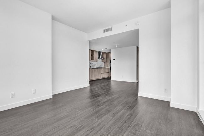 Unfurnished living room featuring dark wood-style flooring and baseboards | Image 9