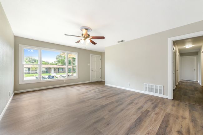 Spare room with wood finished floors and a ceiling fan | Image 4