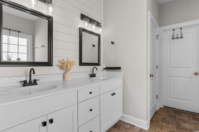 Full bath with stone finish flooring, double vanity, and wooden walls | Image 18