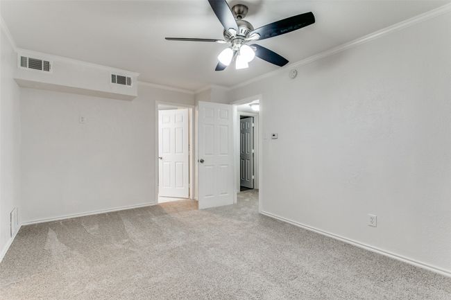 Unfurnished room with visible vents, a ceiling fan, crown molding, baseboards, and carpet flooring | Image 21