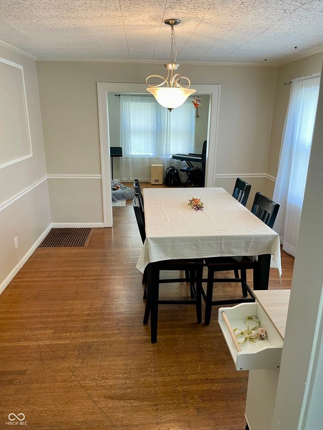 dining area with wood finished floors and ornamental molding | Image 8