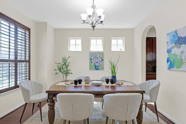 Dining area with inviting chandelier, abundant natural light and arched walkways | Image 4
