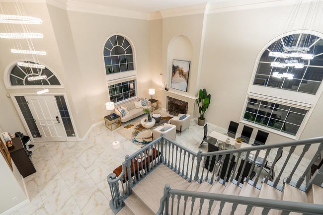 Entrance foyer featuring a chandelier, ornamental molding, baseboards, marble finish floors, and a towering ceiling | Image 16
