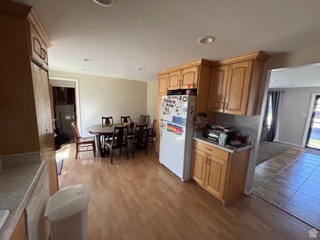 Kitchen featuring freestanding refrigerator, light wood finished floors, light countertops, recessed lighting, and light brown cabinetry | Image 10
