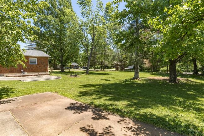 View of green lawn with a patio | Image 9