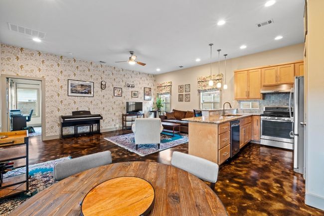 Kitchen with visible vents, a peninsula, under cabinet range hood, light brown cabinetry, and stainless steel appliances | Image 6