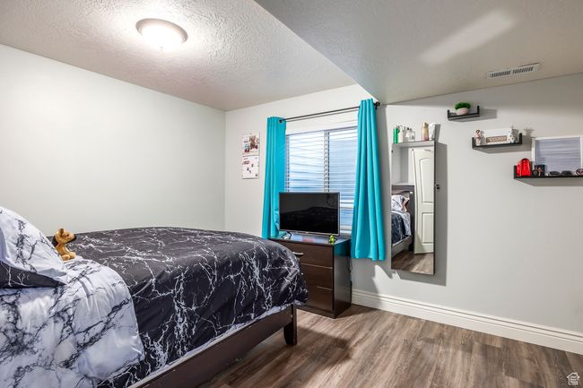 Bedroom with hardwood / wood-style flooring and a textured ceiling | Image 35