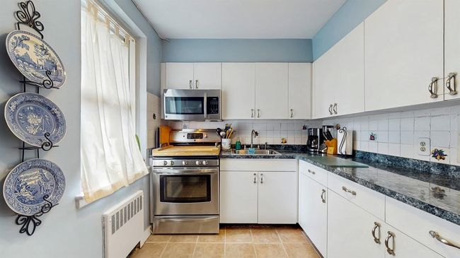 Kitchen featuring appliances with stainless steel finishes, and white cabinets | Image 10