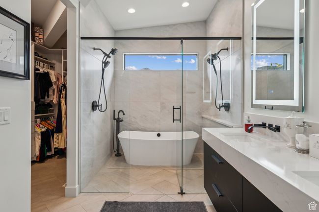 Full bath featuring a sink, double vanity, a stall shower, a spacious closet, and a freestanding tub | Image 34