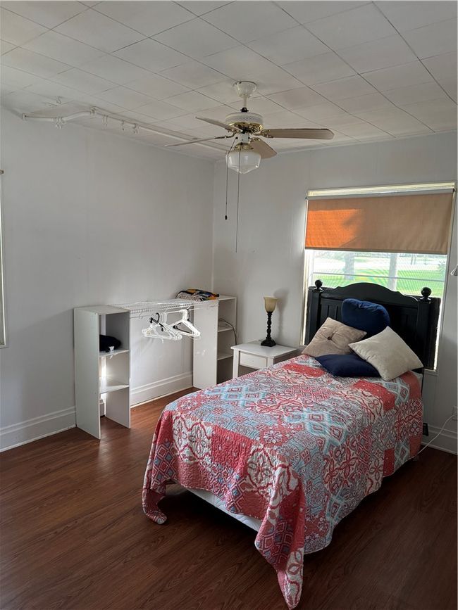 Bedroom featuring wood finished floors, baseboards, and a ceiling fan | Image 12
