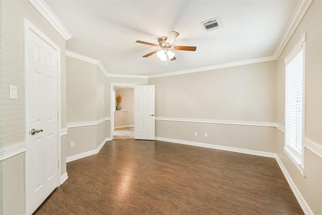 Elegant room featuring easy-care flooring, stylish crown molding, and a ceiling fan comfort. | Image 31