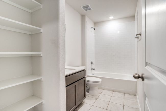 Full bath featuring tile patterned flooring, vanity, and shower / bathtub combination | Image 11
