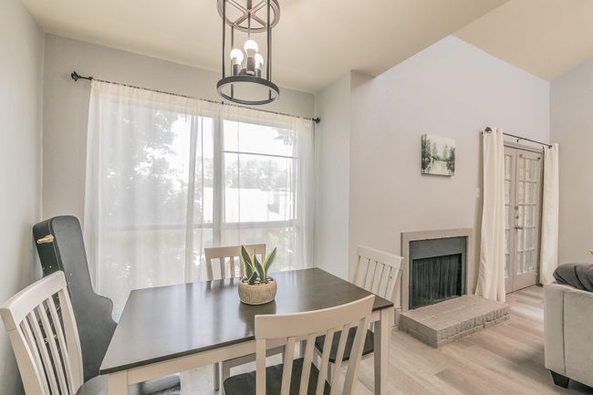 Dining area with a fireplace, a notable chandelier, and light wood-type flooring | Image 8