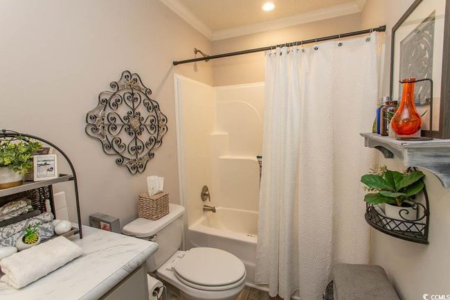 Bathroom featuring shower / tub combo, toilet, and crown molding | Image 21