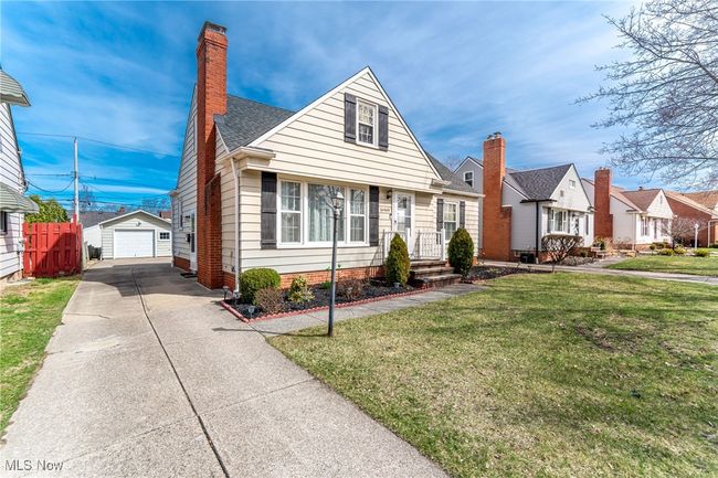 View of front of property with driveway, a front yard, a chimney, an outdoor structure, and a garage | Image 4