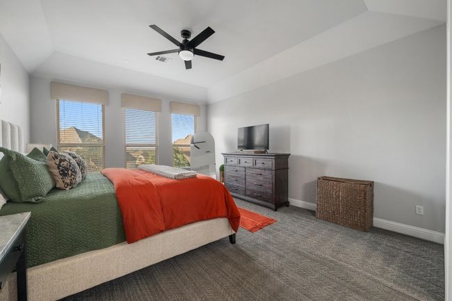 It's easy to wind down from the day in this oversized primary bedroom with plush medium grey carpet, large windows and ceiling fan. | Image 23