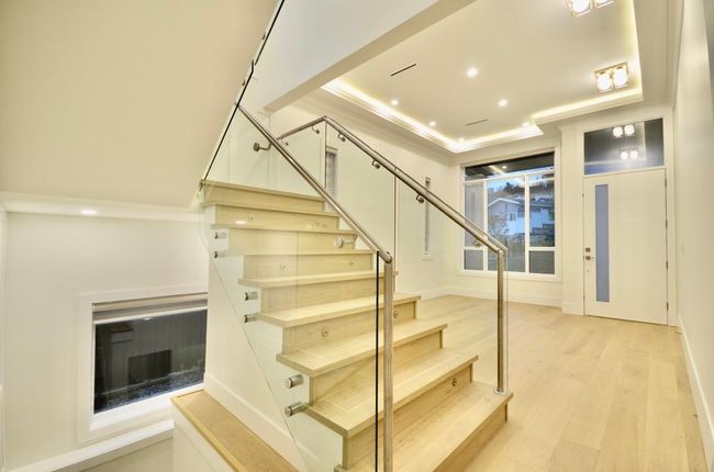 Stairway with wood finished floors, a raised ceiling, recessed lighting, and elevator | Image 23