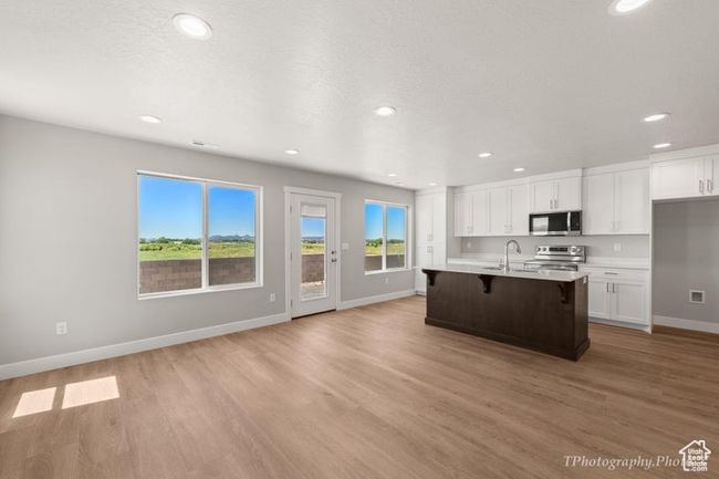 Kitchen featuring appliances with stainless steel finishes, baseboards, white cabinets, and recessed lighting | Image 6