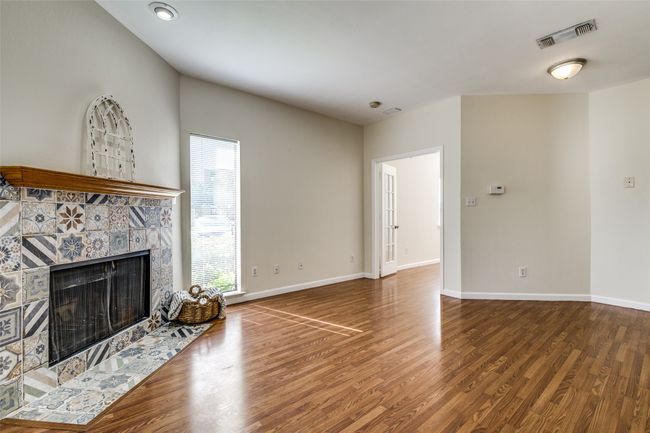 Unfurnished living room featuring baseboards, visible vents, and wood finished floors | Image 6