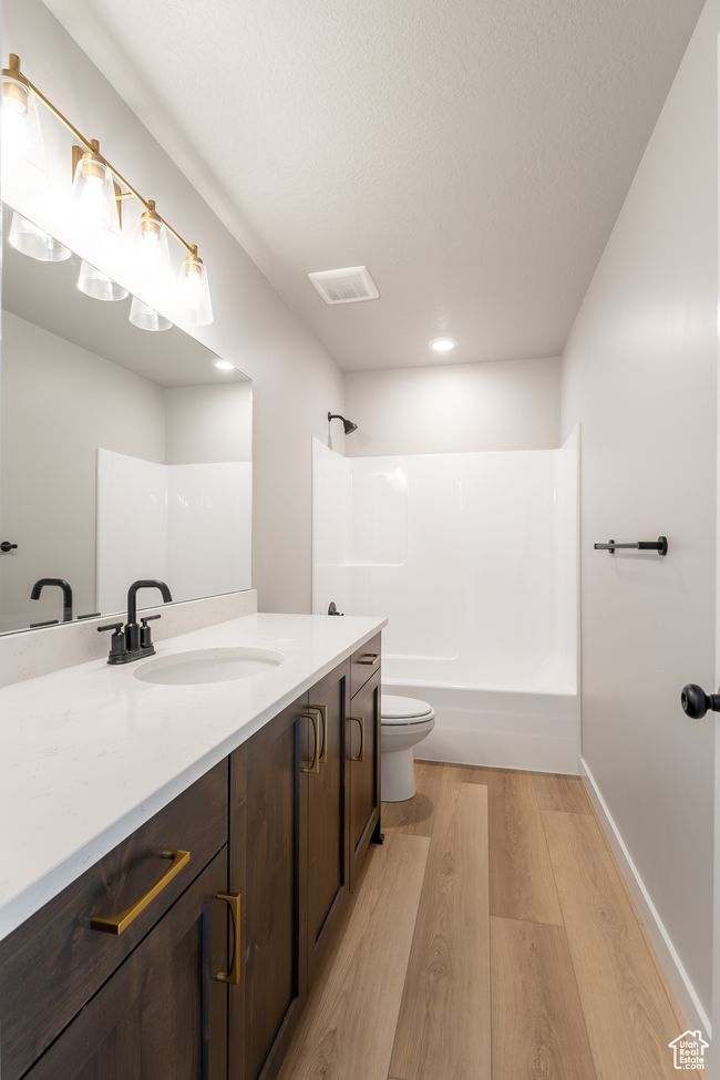 Bathroom with wood finished floors, vanity, tub / shower combination, and recessed lighting | Image 24