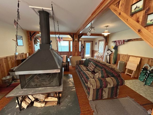 Rec room featuring a wainscoted wall, wooden walls, and a wood stove | Image 14