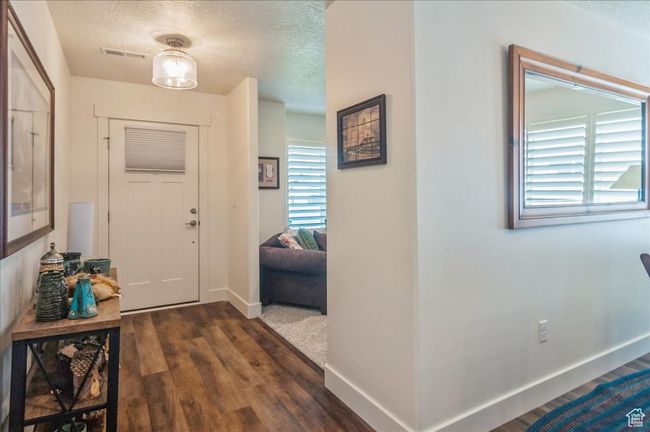 Entryway with a textured ceiling, dark wood-style floors, and baseboards | Image 4