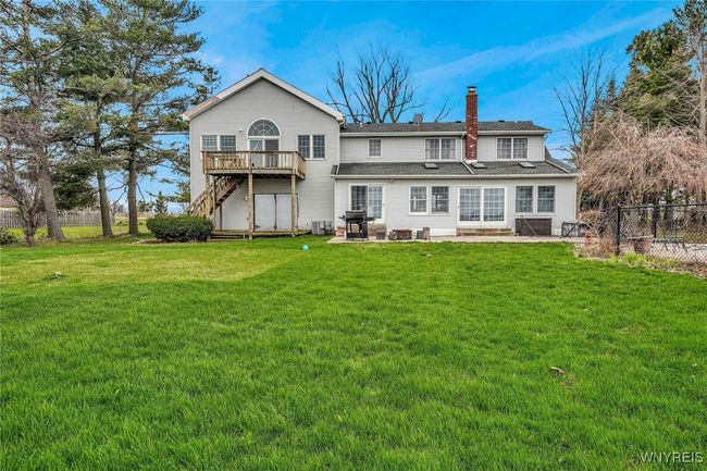 Rear of house with huge concrete patio and multiple exits from the house. | Image 8