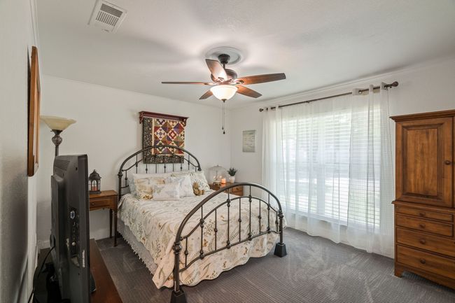 Bedroom featuring dark colored carpet, ceiling fan, and crown molding | Image 27