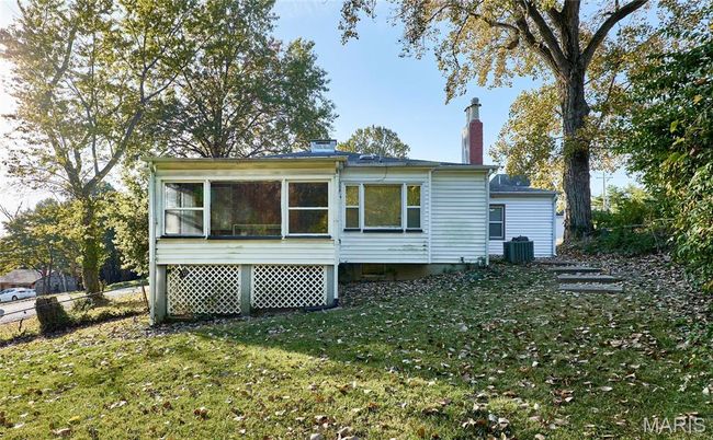 Back of property featuring a yard, a sunroom, and central AC | Image 13
