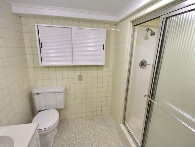Full bath featuring ornamental molding, vanity, a stall shower, toilet, and tile patterned flooring | Image 31