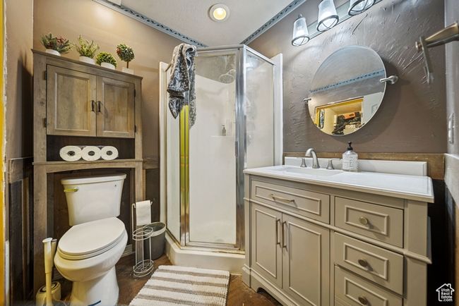 Bathroom with wood finished floors, a stall shower, vanity, and toilet | Image 16