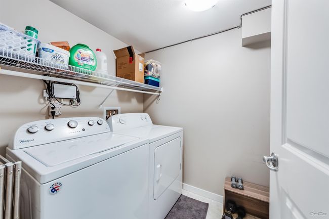 Laundry room with laundry area, light tile patterned floors, baseboards, and washer and clothes dryer | Image 24