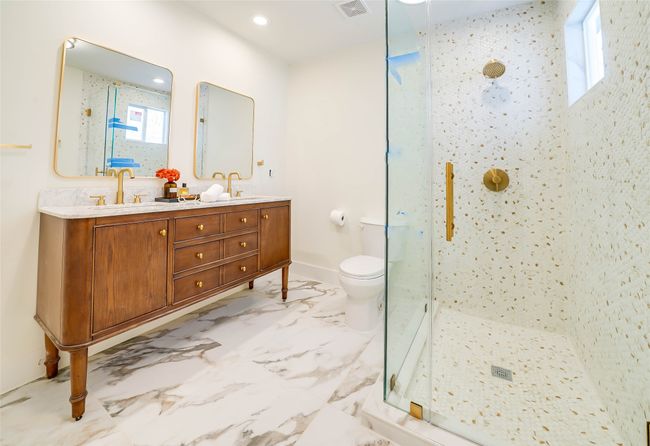 Bathroom with a shower with door, vanity, and toilet | Image 21