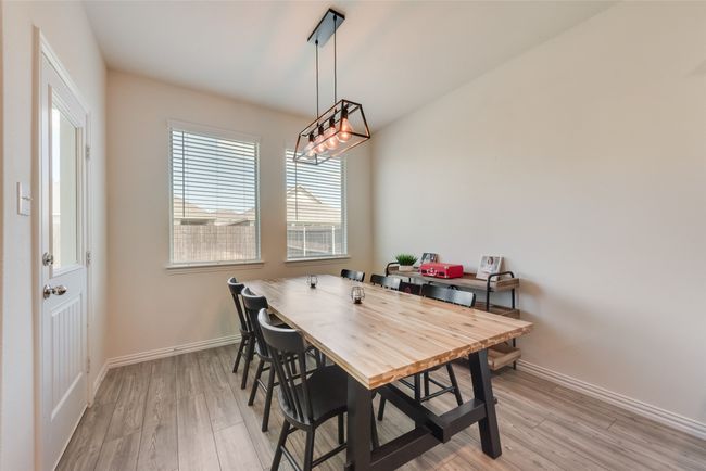 Dining area with light wood-type flooring and a chandelier | Image 9