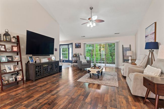 Living area featuring lofted ceiling, wood finished floors, and a ceiling fan | Image 7
