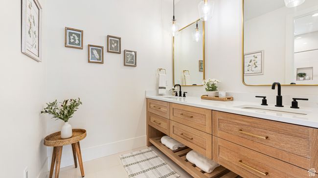 Bathroom featuring baseboards, tile patterned floors, a sink, and double vanity | Image 36