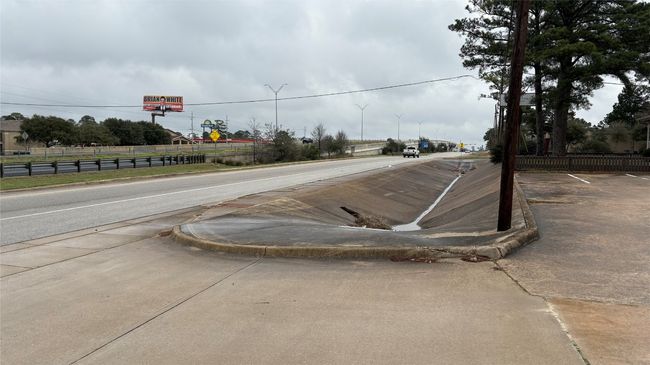 View of road with sidewalks, curbs, street lighting, and traffic signs | Image 26