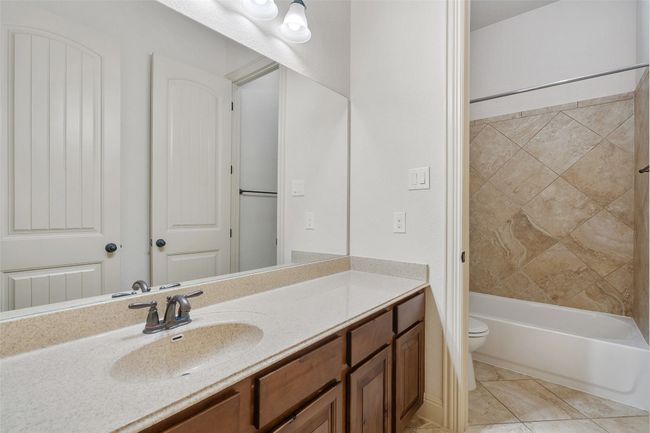 Full bath with vanity, washtub / shower combination, and tile patterned flooring | Image 8
