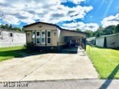 Manufactured / mobile home featuring a front lawn and a carport | Image 1