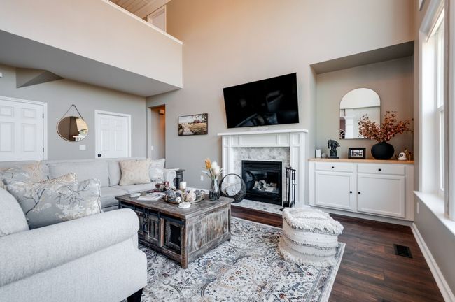 The gas fireplace has a custom mantel and new tile surround and the owners added the custom built-in storage in the nook between the fireplace and the wall of windows. | Image 13