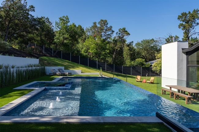 View of swimming pool featuring a pool with connected hot tub | Image 28
