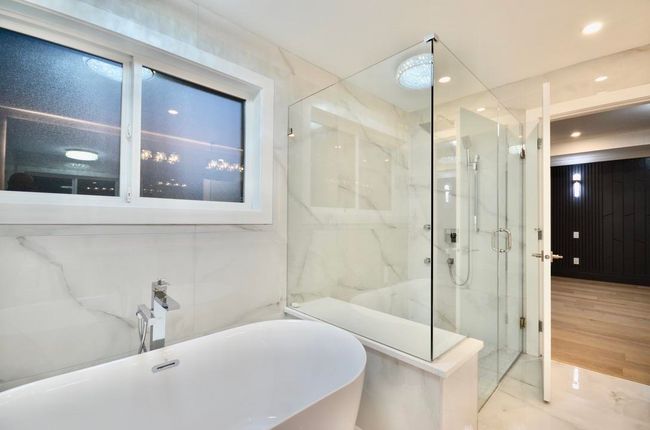 Full bathroom with a marble finish shower, a freestanding tub, and recessed lighting | Image 30