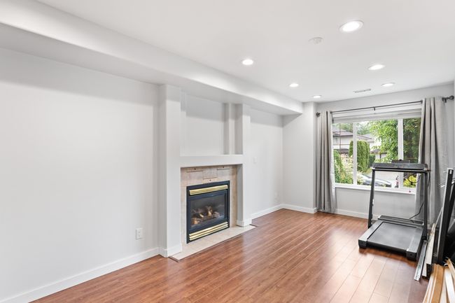 Workout area with recessed lighting, a fireplace, wood finished floors, and baseboards | Image 21